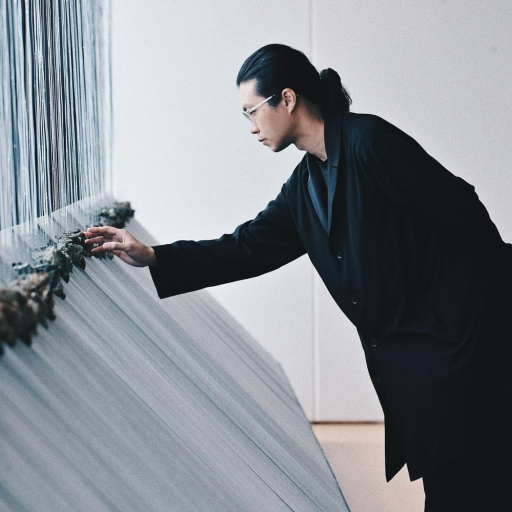 黄昏天台身着深蓝解构西装的中长发男性背影